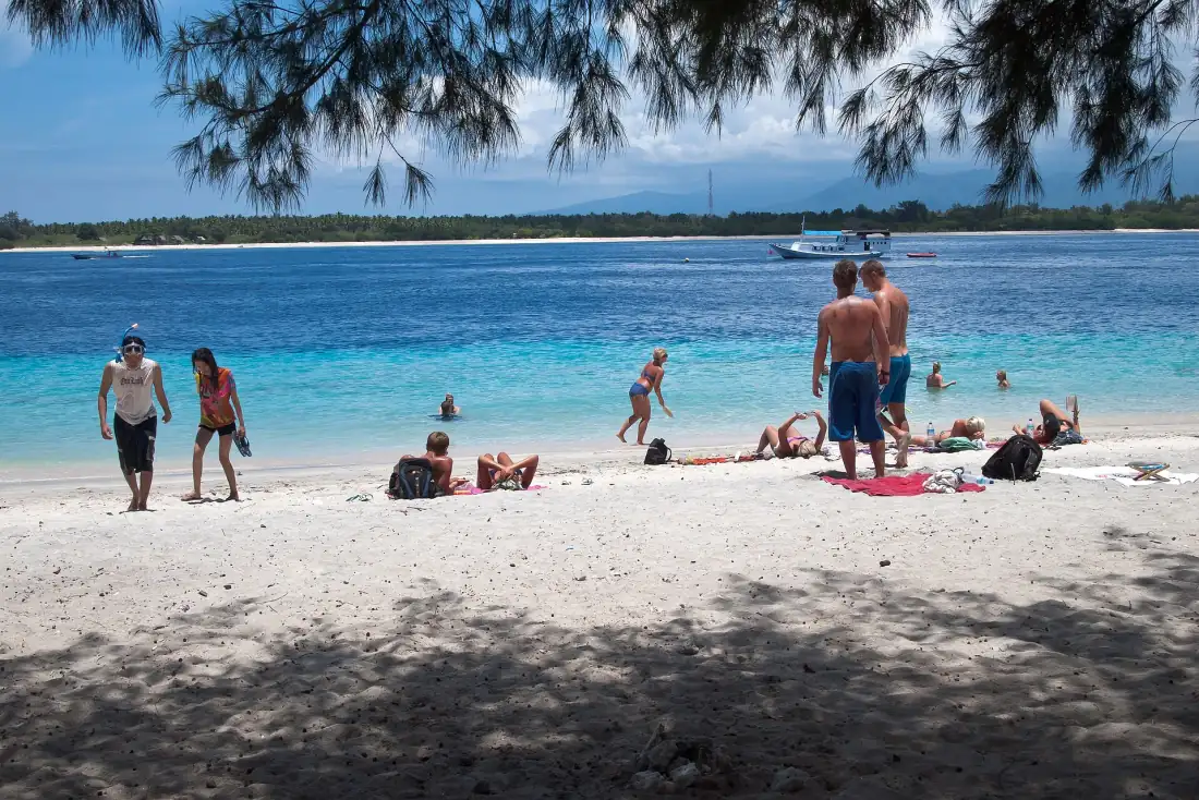 Swimmers on the white-sand beach of Gili Trawangan