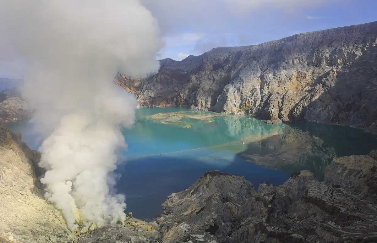 Turquoise acid lake and sulphur smoke in Ijen Crater