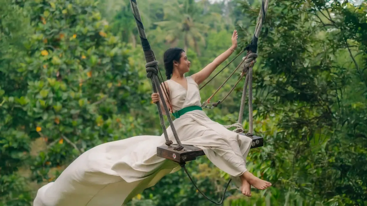Woman in a white dress on a jungle swing in Ubud, Bali